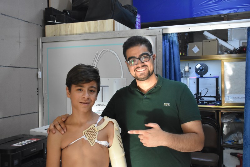 Chapter leader Ahmad Haj Moussa with Muhammad wearing the NIOP 'XO-Shoulder' device in Syria