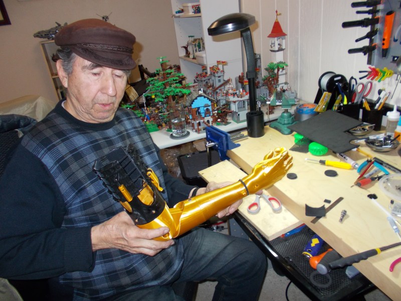 Lorenzo Lopez in Nate's studio with a golden 3D printed prosthetic arm designed after the 'Game of Thrones' series