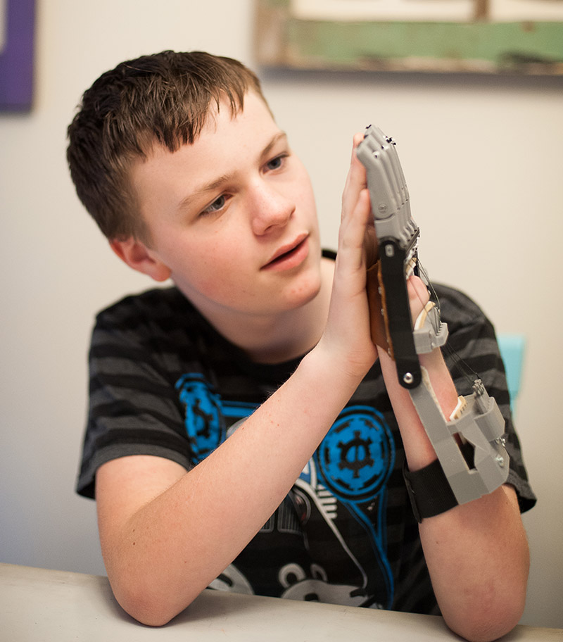 Recipient Ben takes a moment to really look at his new  3d printed e-NABLE hand.